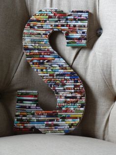 the letter s made out of magazines is sitting on top of a chair with buttons