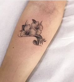 a black and white flower tattoo on the arm