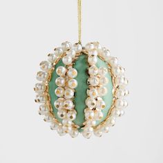 a green ornament with pearls hanging from it