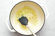 the food is being cooked in the pot on the counter top with a spatula