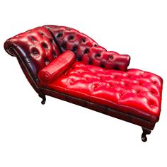 a red leather couch sitting on top of a white floor