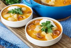 two bowls of soup on a wooden tray