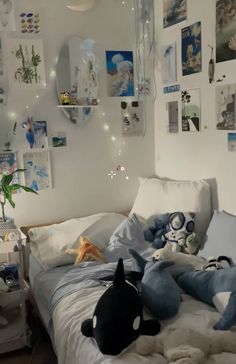 a bed with stuffed animals on top of it in a room filled with pictures and lights