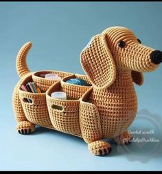 a crocheted dog is holding two cups in it's mouth