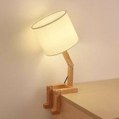 a lamp that is on top of a wooden table next to a wall mounted shelf