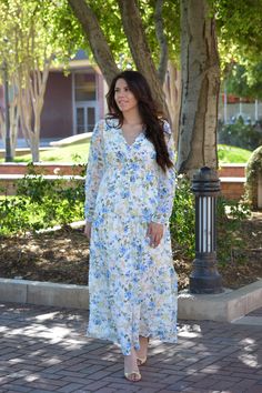 We just love this new brand. And this dress is beautiful! So perfect for spring and summer. Selena features a buttoned front (great for nursing moms), lining to hem, elastic back waist and long sleeve in a tiered design. Florals consist of shades of blue, yellows, and peach. Fabric does not have stretch. Modeled in small 5’6. 100% Polyester - out /100% Rayon - lining XSmall (bust 36”/waist 30-32”/length Small (bust 38”/waist 32-34”/length 56”) Medium (bust 40”/waist 34-36”/length 56”) Large (bus Modest Spring Dress With Smocked Back, Long Sleeve Maxi Dress For Spring Day Out, Spring Maxi Dress With Smocked Back And Empire Waist, Modest Maternity Maxi Dress For Spring, Spring Floral Print Maxi Dress With Empire Waist, Spring Daywear Maxi Dress With Smocked Back, Modest Flowy Maxi Dress For Spring, Spring Maxi Dress With Smocked Back For Daywear, Spring Maternity Midi Dress With Floral Print