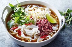 a white bowl filled with meat and noodles