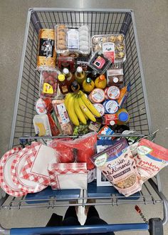 a shopping cart full of food and condiments