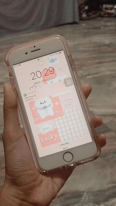 a person holding an iphone in their hand with the screen showing hello kitty on it