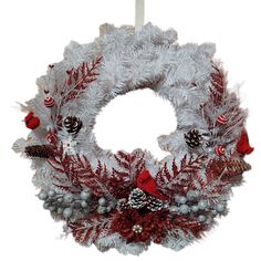 a white wreath with red and silver decorations