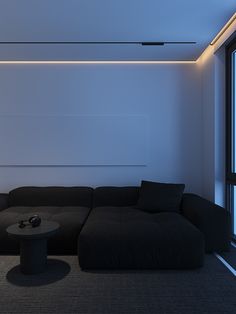 a large black couch sitting in front of a window