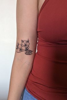 a woman's arm with a flower tattoo on the left side of her arm