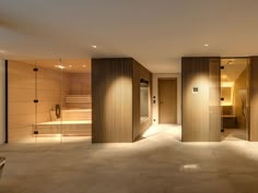 an empty room with wooden partitions and lights on the walls, leading to a jacuzzi tub