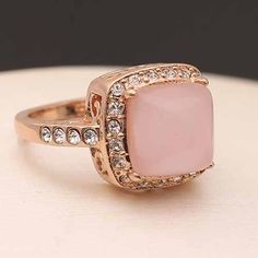 Introducing the "Pink Opal Statement: 18K Rose Gold Ring," a masterpiece of fine jewelry that exudes elegance and sophistication. This exquisite ring is meticulously crafted from 18K rose gold, featuring a stunning pink opal centerpiece surrounded by shimmering rhinestones. The environmental gold plating process ensures a luxurious finish that is both allergy-free and eco-conscious, making this ring a perfect choice for those with sensitive skin and a preference for sustainable luxury. Weighing Opal Statement Ring, Anklet Bracelet, Allergy Free, Pink Ring, Pink Opal, Ring Collections, Eco Conscious, 18k Rose Gold, The Pink