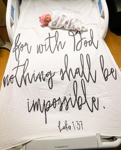 a baby is laying in a crib with a bible verse written on the blanket