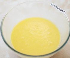 a glass bowl filled with yellow liquid on top of a table