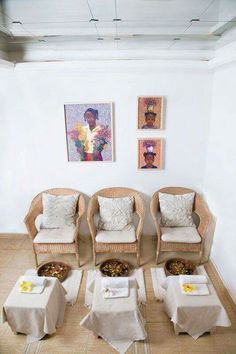 four chairs and two tables in a room with pictures on the wall