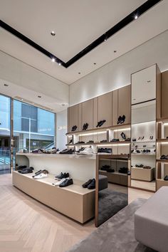 the inside of a shoe store with lots of shoes on shelves and floor to ceiling windows