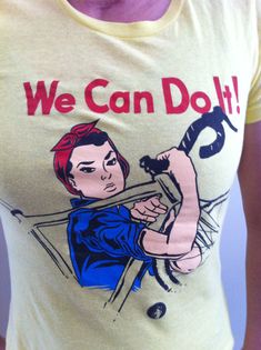 a woman wearing a t - shirt with an image of a woman holding a hammer