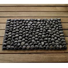 a mat made out of rocks on top of a wooden floor