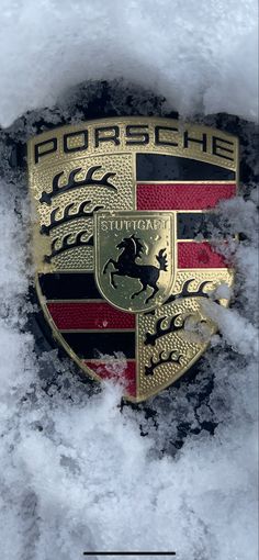 the porsche emblem is covered in snow