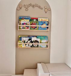 the children's bookshelf has three wooden shelves on each side, and is attached to the wall