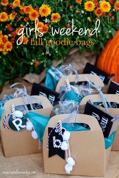 some brown paper bags with black and white tags on them sitting in front of flowers