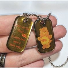 "Vintage Love-A-Lot Bear dog tag necklace. Roughly 26 in. One and a half inch dog tags. Fun and collectible vintage Love-A-Lot Bear dog tag necklace. It's on a silver tone ball chain. It has two silver tone dog tag style pendants with a clear yellow enamel finish. One of the pendants has the 80s style version of Love-A-Lot Bear on it. The other pendant says \"Love-A-Lot Bear. A little love goes a long way.\" Great for collectors and Care Bears fans." Bear Dog, 80s Style, Funky Jewelry, Vintage Harley, Care Bears, Hat Pins, Dog Tag, Vintage Love, Ball Chain