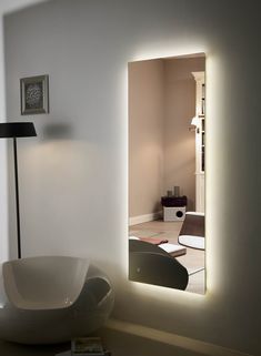 a white bowl sitting on top of a table next to a mirror with lights in it