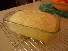 a loaf of bread sitting on top of a cooling rack next to an orange bowl