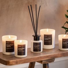 five candles on a table with one candle in the middle and two are filled with reeds