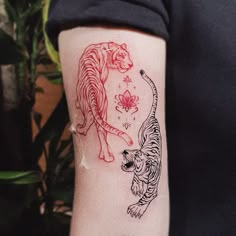 a woman's arm with a tiger and flower tattoo on it