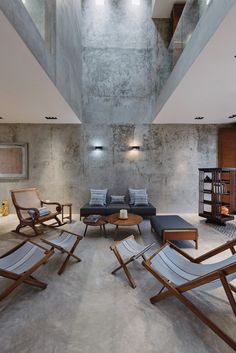 a living room filled with lots of furniture next to a tall ceiling mounted light fixture