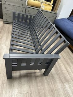 a metal bed frame sitting on top of a hard wood floor next to dressers