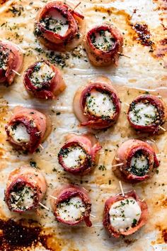 small appetizers with meat and cheese are on a sheet of waxed paper