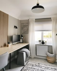 a room with a desk, chair and computer on it in front of a window