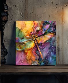 a colorful dragonfly painting on a wall next to a lamp