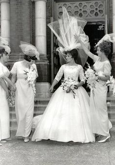 black and white photograph of four bridesmaids in front of a building with veils over their heads