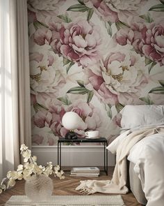 a bed room with a neatly made bed and flowers on the wall