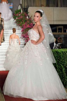 a woman in a wedding dress on the runway