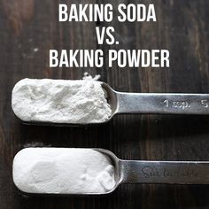 two spoons filled with baking powder on top of a wooden table