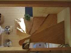 the view from above looking down at a spiral staircase in a tiny house with wood paneling