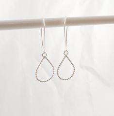 "Beautiful sterling silver teardrops make these geometric earrings swing and shine!  These beauties would make the perfect gift for you, your daughter or something special for your bridesmaids.   Ear wires are hand shaped from 20 gauge sterling silver wire.  Sterling silver teardrops are formed from beaded wire that I  hammer flat before being tumbling to a beautiful shiny finish.  Each earring measures 1.75 inches from top of ear hook to bottom of earring dangle and 5/8 of an inch wide. All components of these earrings are .925 sterling silver. *Love the earrings, but want a different shape!  Request a custom order, I can provide you with your choice of shapes.  Thanks!* **Brides...please contact me for a custom listing if you would like to purchase 4 or more pairs of earrings. I offer br Silver Wire-wrapped Teardrop Earrings, Sterling Silver Teardrop Pendant Jewelry With Ear Wire, Sterling Silver Teardrop Pendant With Ear Wire, Sterling Silver Linear Drop Earrings With Pearl, Sterling Silver Linear Pearl Drop Earrings, Adjustable Teardrop Linear Earrings With Ear Wire, Elegant Sterling Silver Teardrop Threader Earrings, Silver Teardrop Linear Earrings With Pearl Drop, Silver Teardrop Linear Earrings