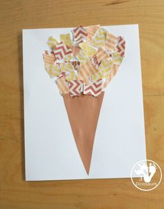 an ice cream cone made out of paper on top of a piece of white paper