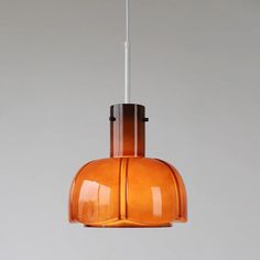 an orange glass light hanging from a ceiling