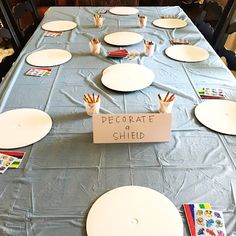 the table is set up with paper plates and place cards for each individual to write on