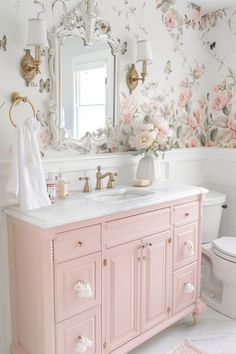 a bathroom with pink vanity and floral wallpaper