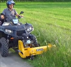 a man riding on the back of an atv with a yellow mower attached to it