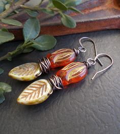 "Colorful woodland earrings featuring beautiful Czech glass beads. The flower drops are a bright koi orange with a rustic gold metallic finish. The leaves are light green with a terracotta and caramel finish. I've wrapped the beads with solid copper wire which I have oxidized. I made matching solid copper ear wires. These earrings are a fun addition to your boho collection and a great gift for someone who loves nature or rustic style. You can select copper niobium or copper plated lever back ear Orange Adjustable Dangle Flower Earrings, Bohemian Orange Czech Glass Earrings, Unique Orange Flower-shaped Jewelry, Unique Orange Flower Shaped Jewelry, Orange Czech Glass Jewelry With Ear Wire, Bohemian Orange Flower-shaped Jewelry, Artistic Handmade Orange Jewelry, Artistic Orange Dangle Jewelry, Orange Bohemian Flower Earrings For Gift