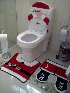 a bathroom with santa claus toilet cover and rugs